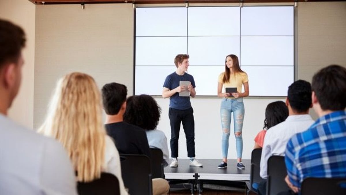 Teen maliciously complies during group project presentation after partner says 'shut up.'